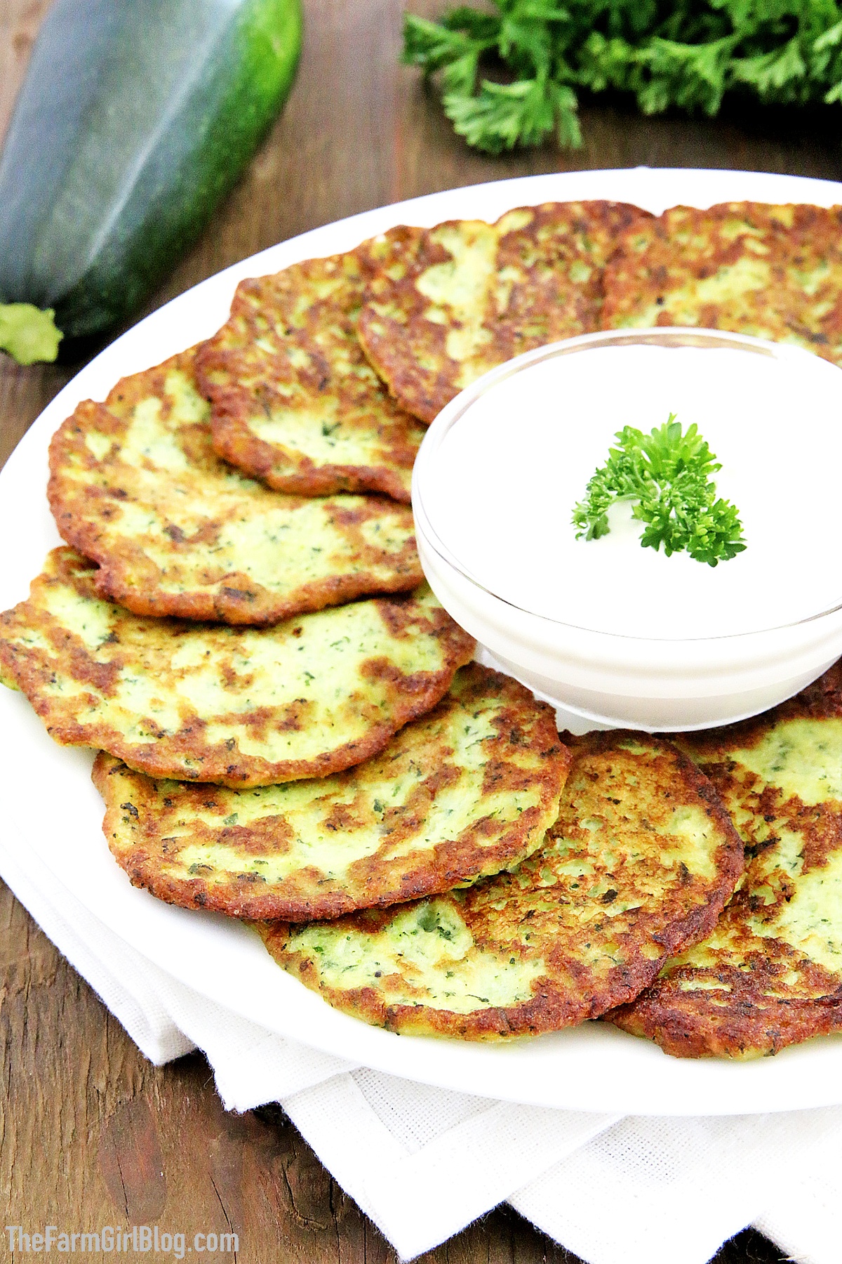 These Zucchini Pancakes are a wonderful way to enjoy the abundance of your garden-fresh zucchinis. They are golden and crisp on the outside and soft and moist on the inside. The addition of fresh homegrown garlic adds a savory, robust kick. There's so much flavor in these pancakes, you just can't stop enjoying them. #zucchinipancakes #homegrownzucchini #organicgarlic #organiczucchini #thefarmgirlblog
